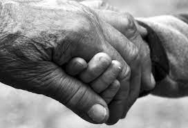 Close up of older-looking hands holding another's hand, black and white